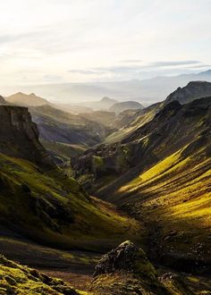 the mountains are covered in green and yellow grass