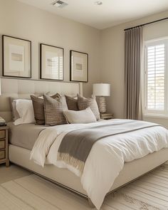 a large bed sitting in a bedroom next to two windows