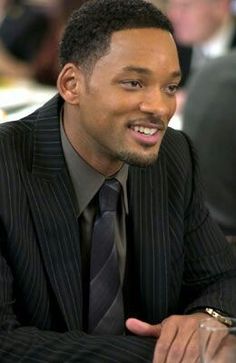 a man wearing a suit and tie sitting at a table