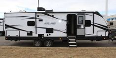 a white and black rv parked in a parking lot