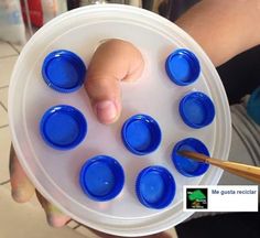 a person holding a plate with blue cups in it