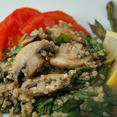 a white plate topped with meat and veggies next to a slice of lemon