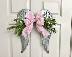 a metal angel door hanger decorated with pink and white flowers