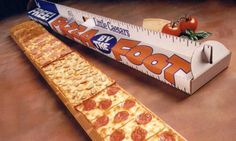 two slices of pizza sitting on top of a table next to a tape measure ruler