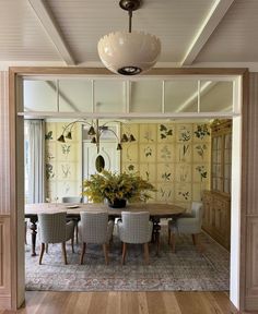 a dining room table with chairs and a potted plant