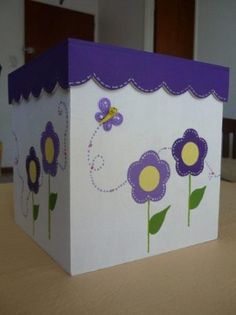 a white box with purple and yellow flowers painted on it, sitting on a table