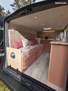 the back end of a vehicle with a couch and kitchen in it's trunk