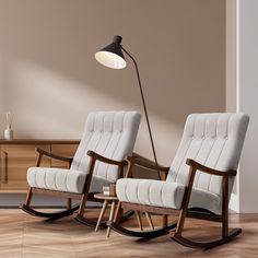 two rocking chairs sitting next to each other in front of a wall with a lamp on it