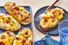 baked potatoes with bacon and cheese on a plate next to a glass of water