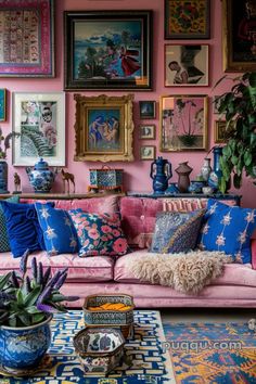 a living room filled with lots of furniture and pictures on the wall above it's pink couch