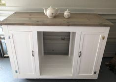 a white cabinet with two teapots sitting on it's top and bottom