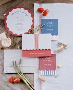 the wedding stationery is laid out on top of each other with flowers and place cards