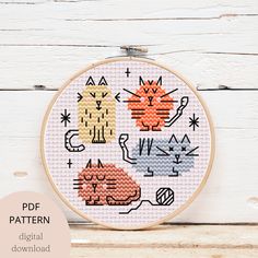 a cross stitch pattern with cats in different colors and sizes on a white wooden background