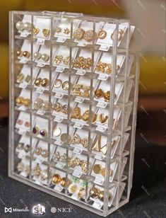 a clear display case filled with lots of different types of earrings on it's sides