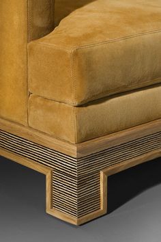 an upholstered couch with wood trimmings on the arm and back ends