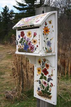 a painted mailbox sitting on top of a wooden post