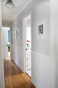 an empty hallway with white walls and wood floors