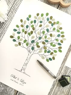 a wedding guest book with a tree drawn on it and a stamper next to it