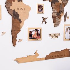 a map of the world made out of wood with pictures pinned to it's sides