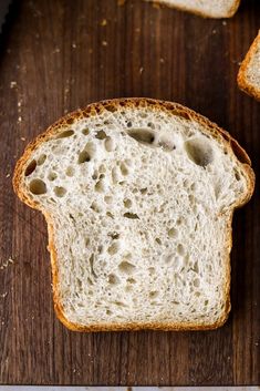 two slices of white bread sitting on top of a wooden table next to each other