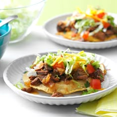 two white plates filled with food on top of a table