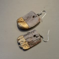 two wooden earrings with metal hooks on them