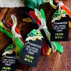 some colorful candy candies are tied up on a wooden table with tags that say, thank you for coming to party today