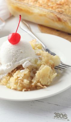 a white plate topped with an ice cream sundae next to a fork and pie