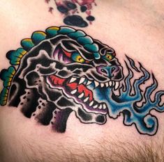 a man with a tattoo on his chest has a dragon head and flames coming out of it