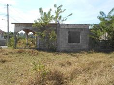 an old brick building sitting in the middle of a field