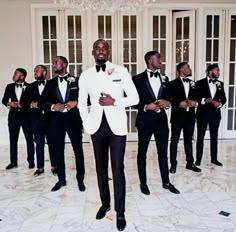 a group of men in tuxedos standing next to each other