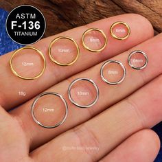 four different sizes of rings on someone's hand with measurements for each ring in the foreground