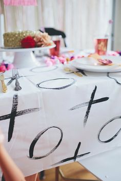 a white table topped with a cake covered in frosting and black numbers on it