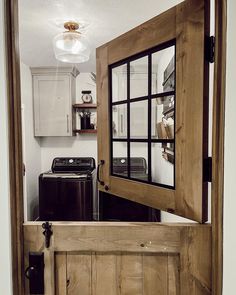 an open door leading to a kitchen with black appliances