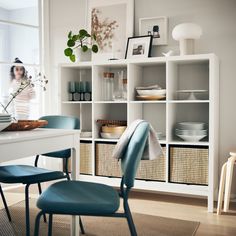 a white table with blue chairs and baskets on it