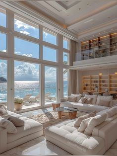 a living room filled with white furniture and large windows overlooking the ocean on a sunny day