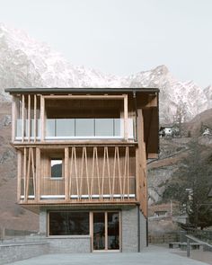 a wooden building with mountains in the background