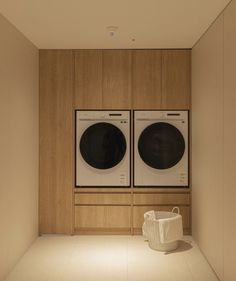 a washer and dryer in a room with wood paneling on the walls