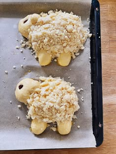 two pastries are sitting on top of a baking sheet covered in crumbs