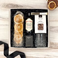 an assortment of liquors in a gift box with a black ribbon on the side