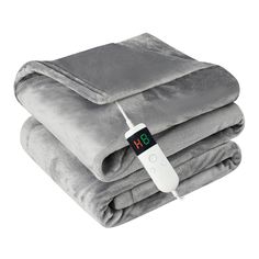 an electric blanket with a thermometer on it and two blankets folded in front