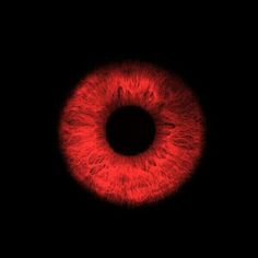 an eyeball is shown in the dark with red light coming from its center and around it