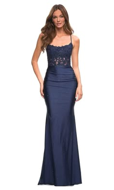 Make a memorable splash at your upscale evening in this lux formal gown by La Femme 30728. Beautifully designed in lace appliques with speckled beads on a fitted bodice, this gown showcases a sleeveless, scoop neckline supported with spaghetti straps that trail to the open back for crisscross style. The bodice is styled with ruching and leads to the full-length trumpet skirt with sweep train. Orchestrate your moment to stand out in this La Femme masterpiece. Model is wearing Navy color. Style: l Fitted Blue Prom Dress, Navy Blue Dress Long, Prom Dresses Fitted Long, Gowns Elegant, Navy Blue Prom Dress Fitted, Formal Dresses Navy Blue, Navyblue Promdress, Prom Dresses Blue Navy, Dark Blue Lace Dress