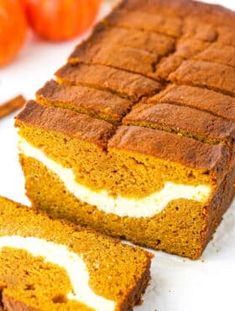 slices of pumpkin bread on a white plate with oranges in the background and one slice cut off