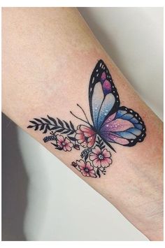 a colorful butterfly tattoo on the left forearm and right arm, with flowers around it