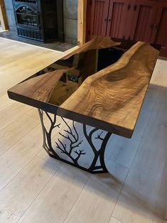 a wooden table sitting on top of a hard wood floor next to a fire place