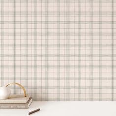 a white table with two books and an egg on it next to a wallpapered background