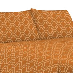 an orange and white bed sheet set with matching pillow cases on top of each other