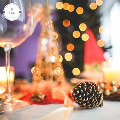 a pine cone sitting on top of a table next to a wine glass and candle