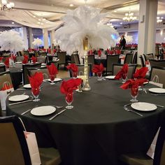 the tables are set with red napkins and white centerpieces for an elegant event